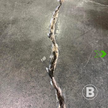 alt="Visible crack in a concrete slab."